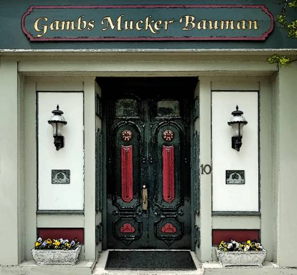 The dark green double doors of the Vater Building at 10 North 4th Street, with the Gambs Mucker Bauman sign above them and planters either side
